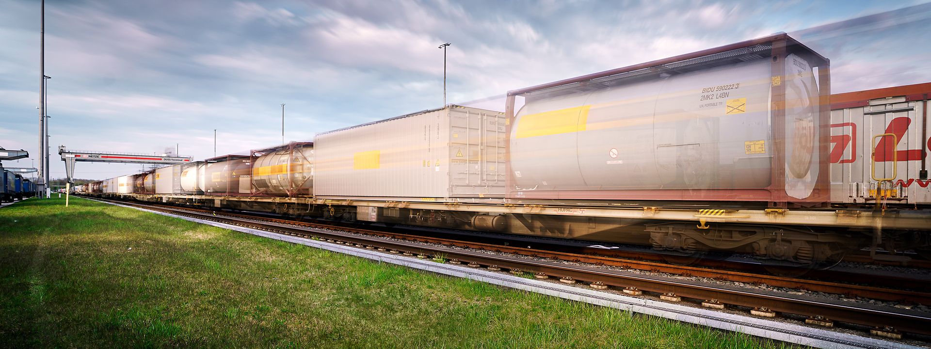 A freight train with tank containers arrives at a transhipment terminal.