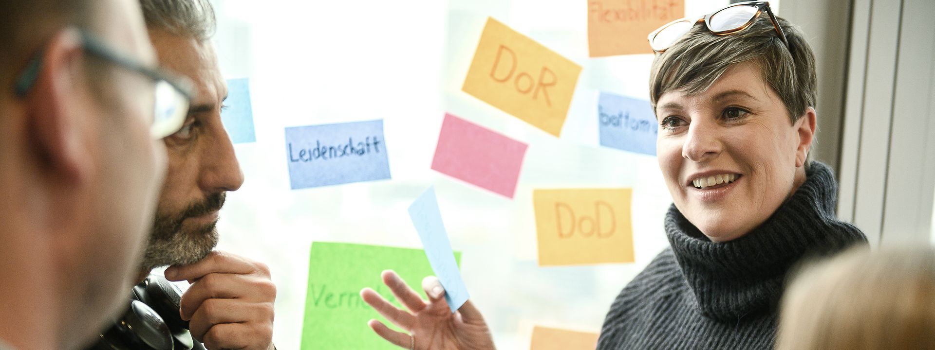 Vier Personen vor Whiteboard im Gespräch