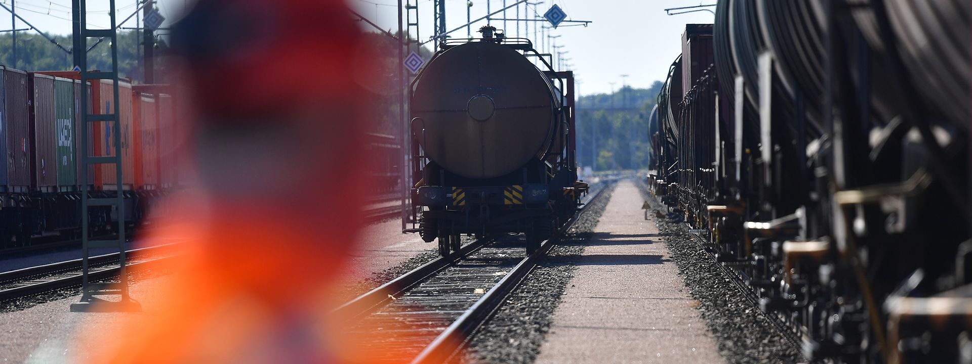DB-Mitarbeiter schaut auf stehende Züge am Gleis