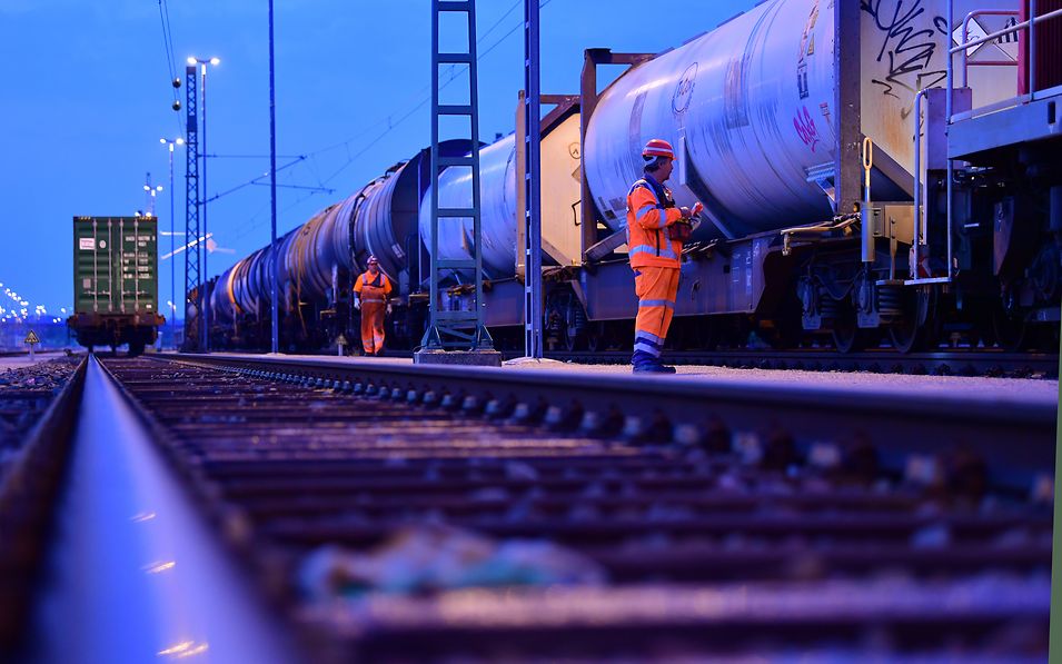 Arbeiter überprüft einen Zug mit Tankcontainer