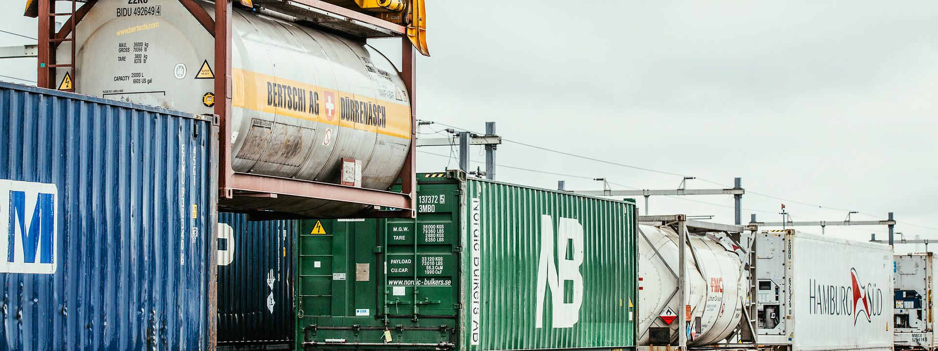 Ein Tankcontainer wird auf die Schiene verladen.