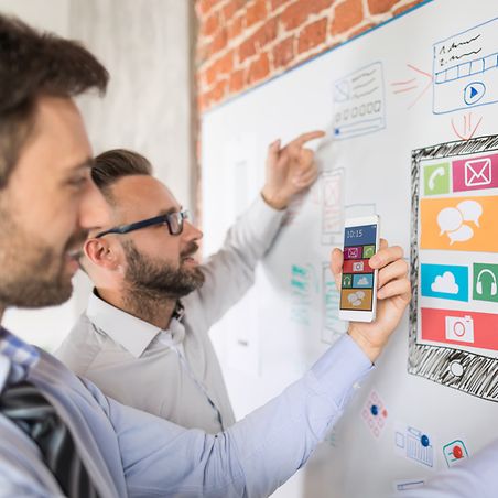 Zwei Mitarbeiter planen die nächsten Arbeitsschritte im Entwicklungsprojekt.