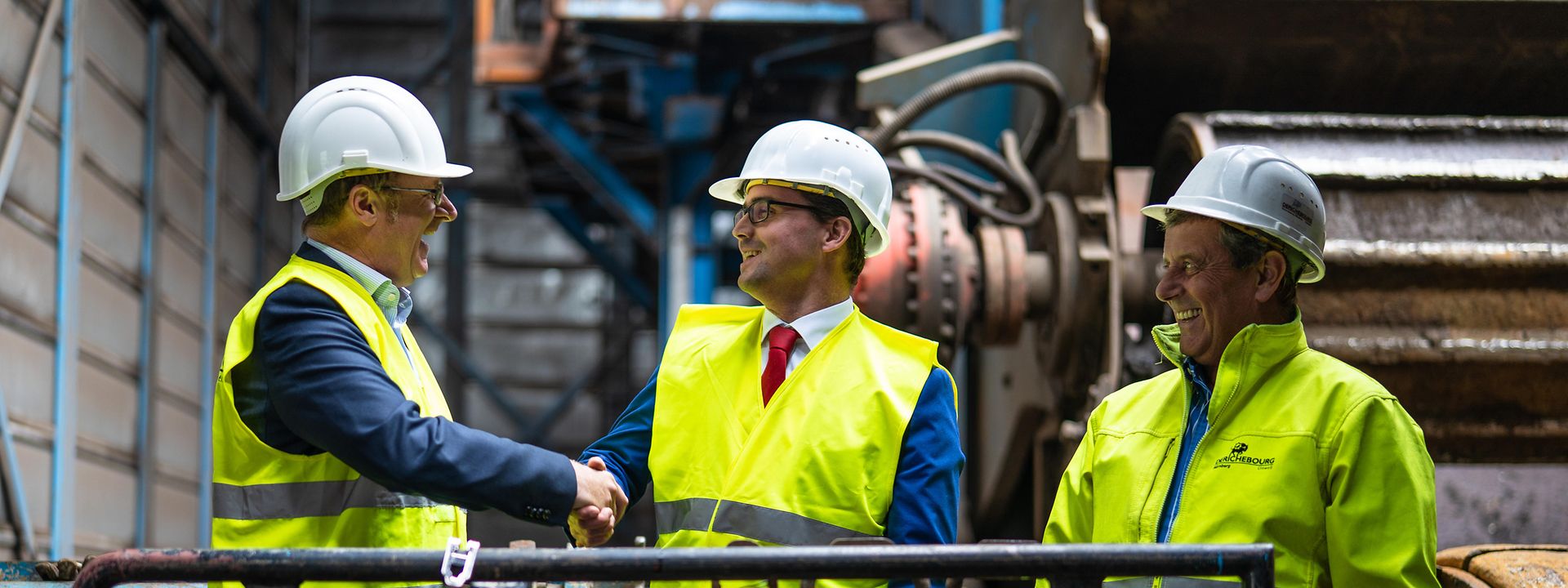 DB Cargo staff management in yellow high-visibility waistcoats greet each other