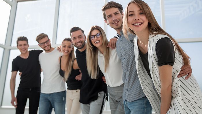 A group of young employees smiling at the camera.