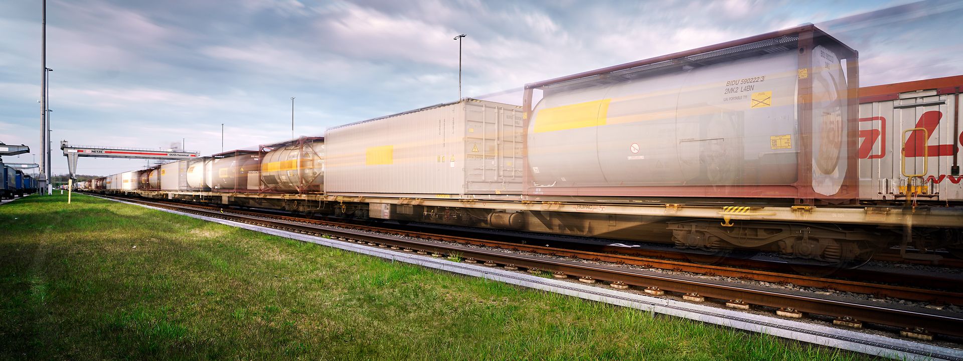 A freight train with tank containers arrives at a transhipment terminal.