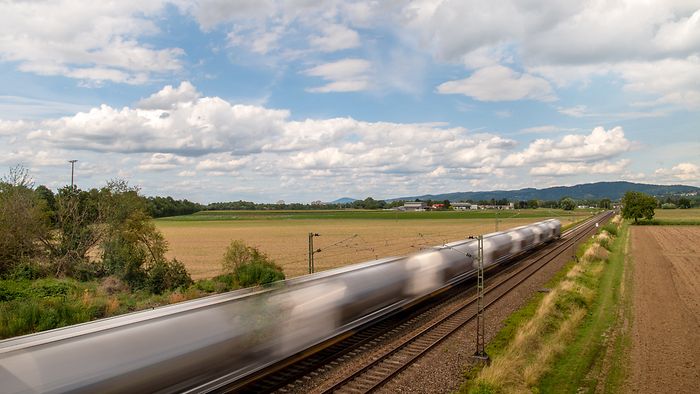 A shuttle train speeds through the countryside.