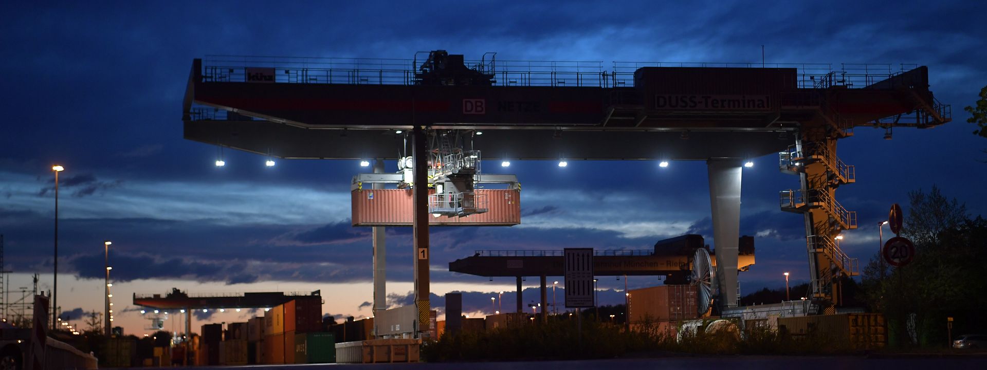 A container being transhipped by night