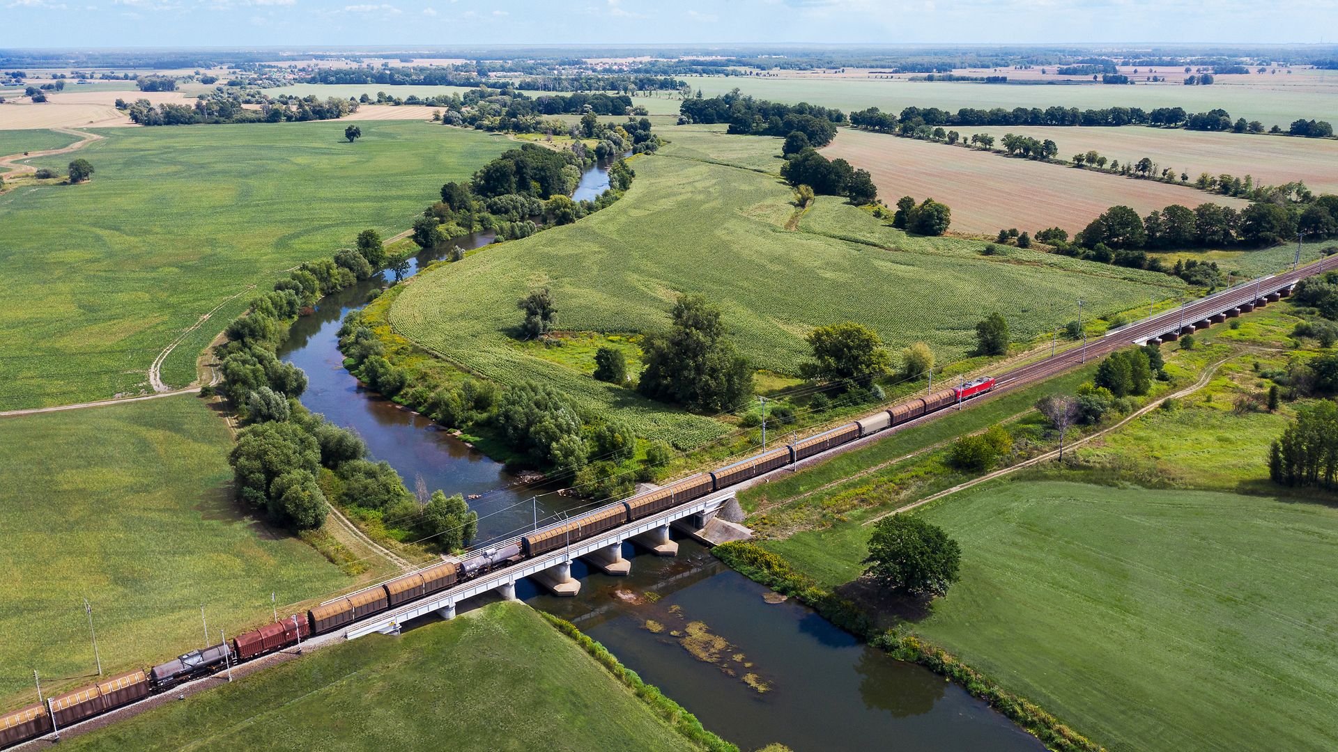 Train passes through green landscape