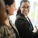 Two women talking in front of a flip chart