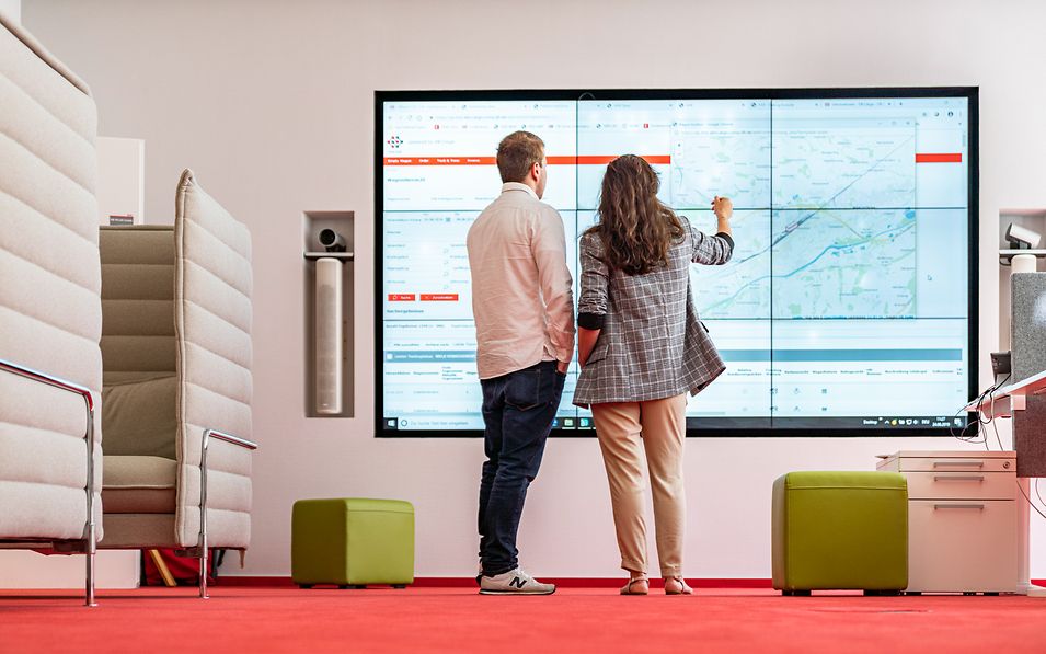 Man and woman standing in front of a planning smartboard.
