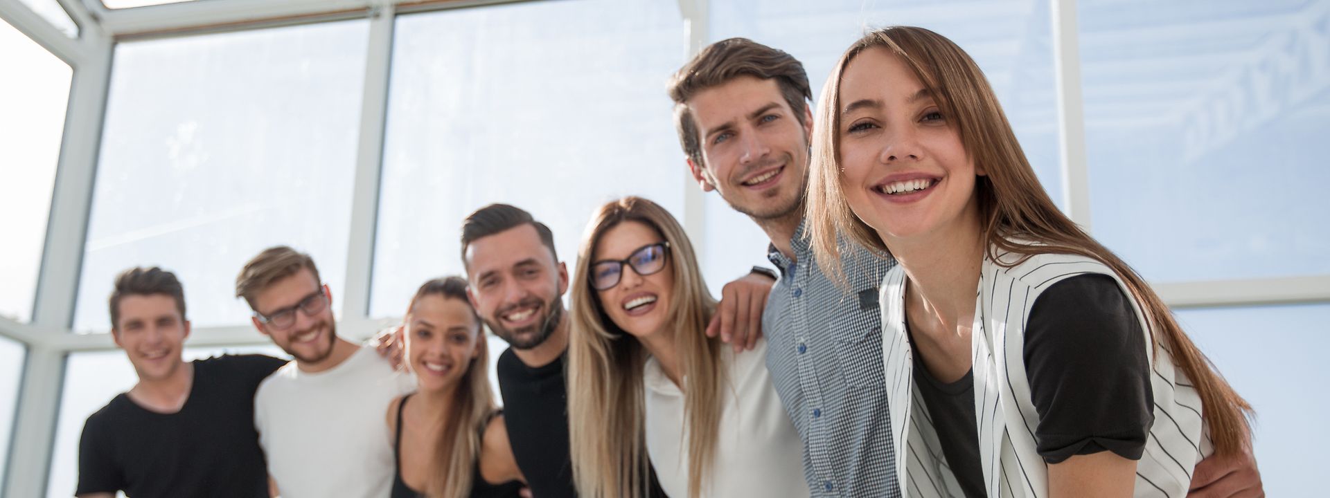 A group of young employees smiling at the camera.