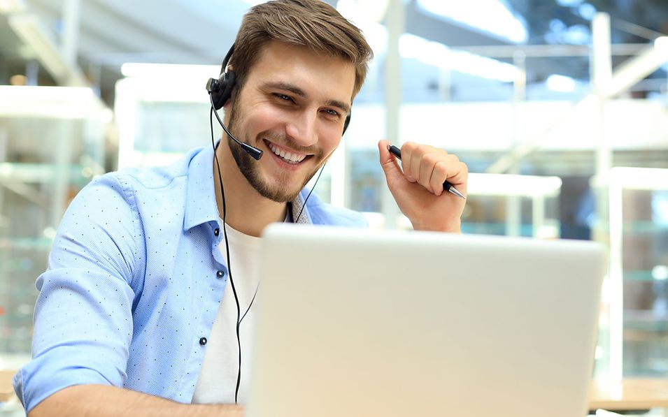 Young man with headset at a laptop.